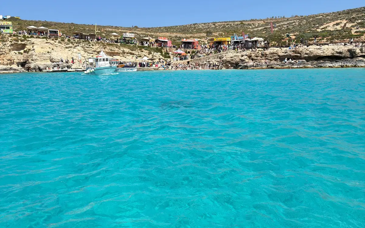 Ein Ausflugsboot auf dem türkisfarbenen Wasser einer Lagune