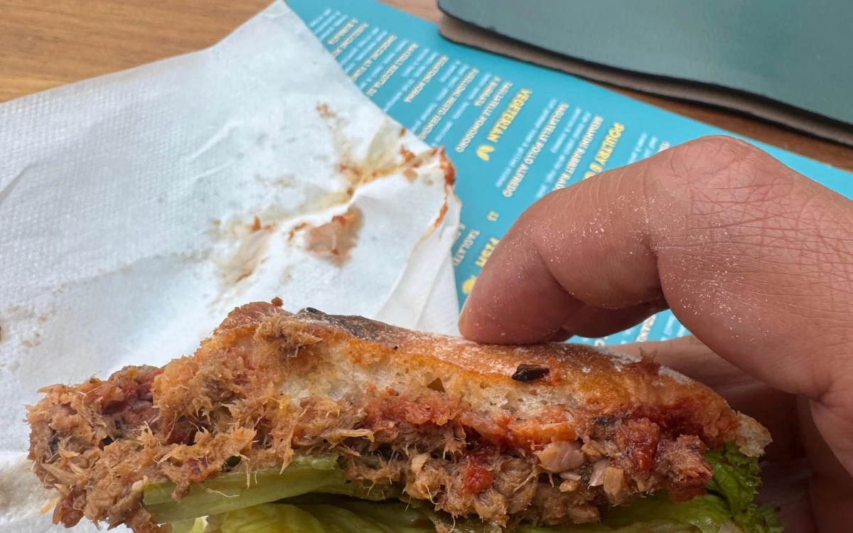 Un panecillo crujiente con relleno salado y lechuga