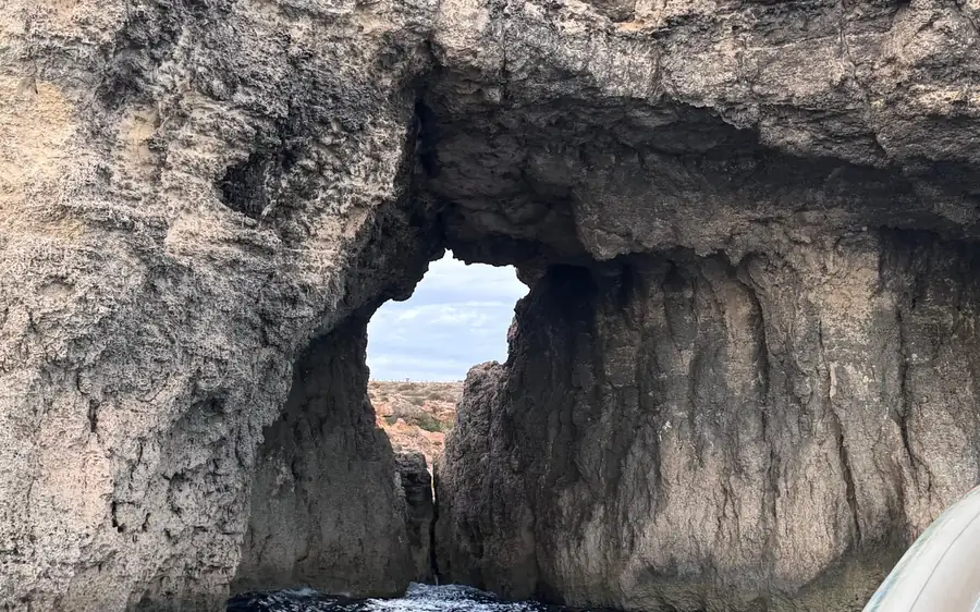 Eine fensterförmige Öffnung in einer Meereshöhlenwand, vom Boot aus gesehen