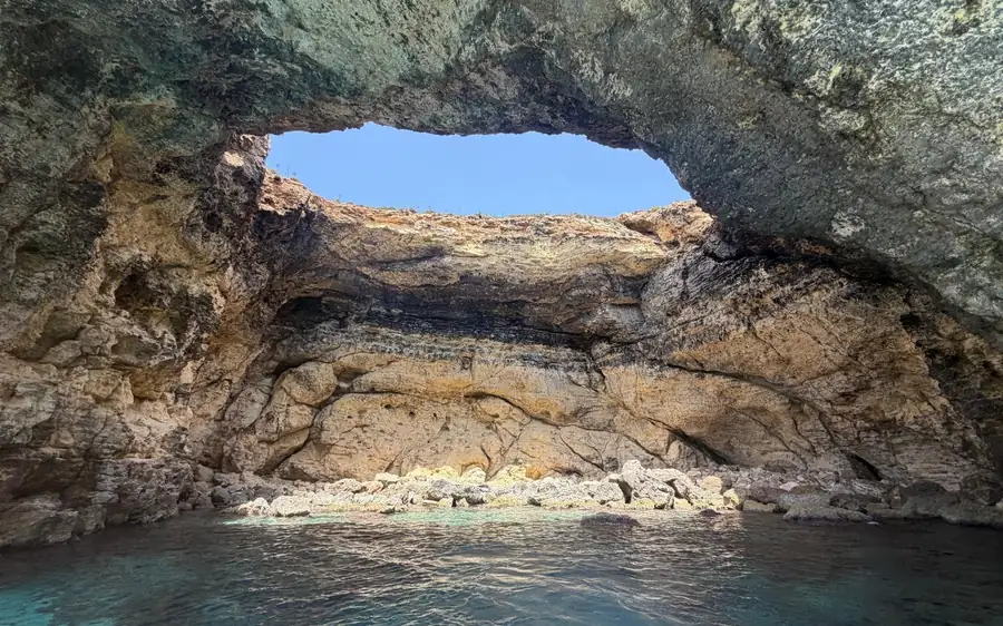 Ein breiter Meeresbogen mit Felsen darin, vom Wasser aus gesehen
