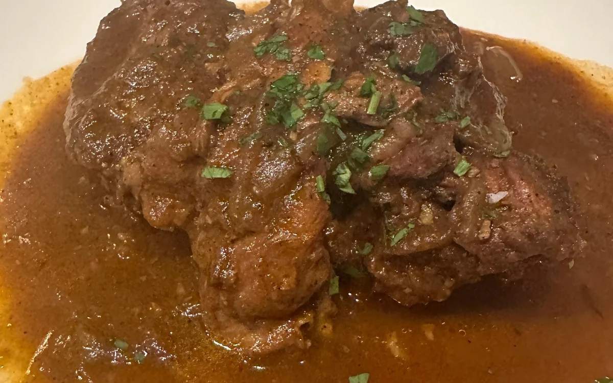 Carne en una salsa oscura y contundente espolvoreada con perejil picado
